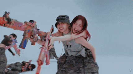 a woman is holding a gun while another woman holds a gun