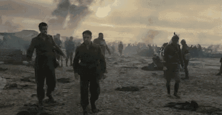 a group of soldiers are walking across a battlefield .