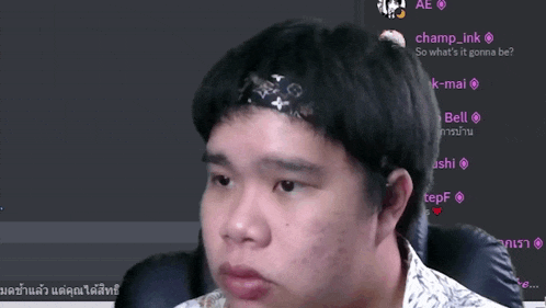 a man wearing a headband with the word louis vuitton on it looks at the camera