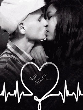 a black and white photo of a man and woman kissing with a heart in the background