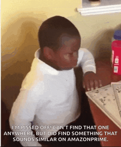 a little boy is sitting at a desk with a sticker that says i 'm pissed off can 't find that one