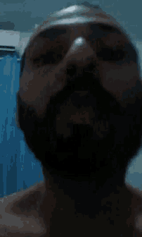 a man with a beard is looking at the camera