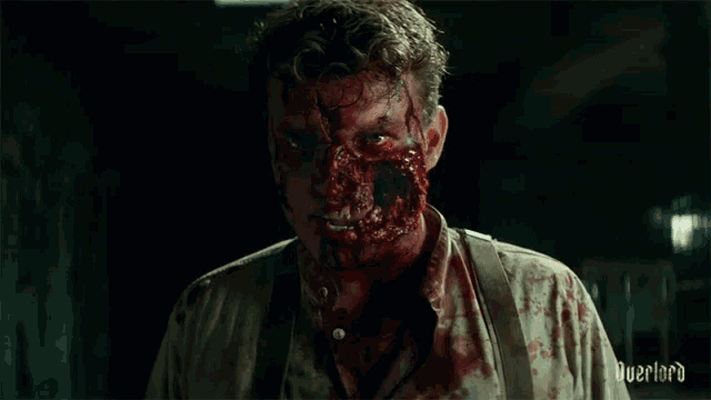 a man with blood on his face has the word overlord on his shirt