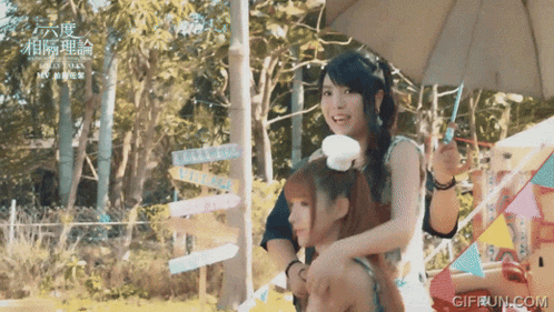 a girl is sitting on a man 's shoulders with a sign in the background that says ' love story '