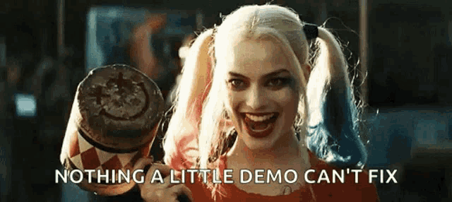 harley quinn is holding a mallet with a smiley face on it and smiling .