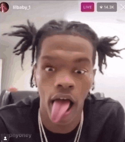 a man with pigtails sticking his tongue out in front of a live sign