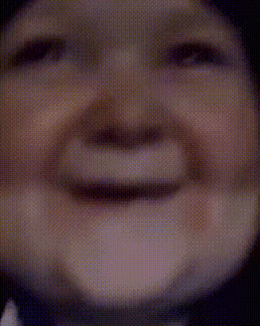 a close up of a baby 's face with its mouth open and a blurry background .