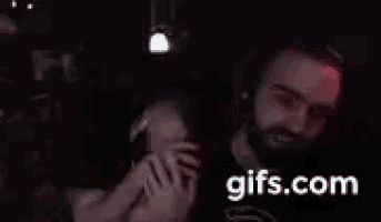 a man with a beard is dancing in a dark room with gifs.com in the corner