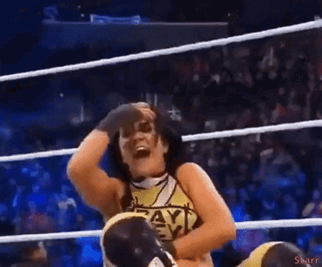a woman in a wrestling ring wearing a shirt that says payback on it