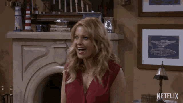 a woman waving in front of a fireplace with a netflix logo