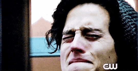 a close up of a man 's face with his eyes closed and a cw logo in the corner .