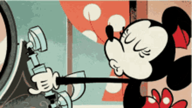 a cartoon drawing of minnie mouse looking at herself in the mirror