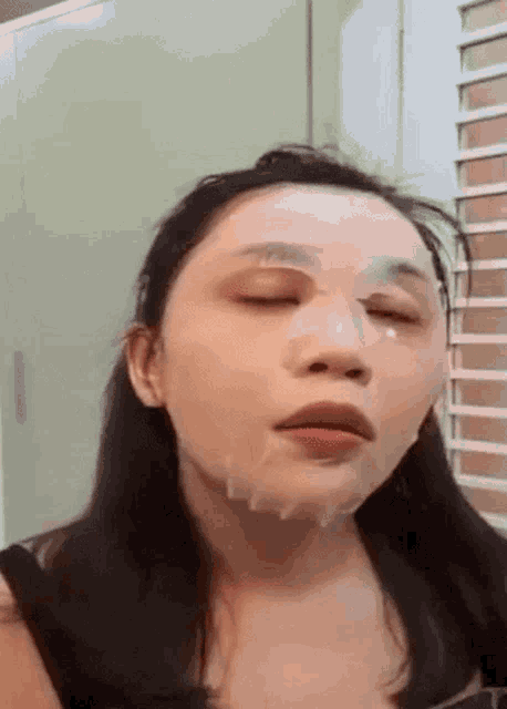 a woman is wearing a mask on her face and making a funny face .