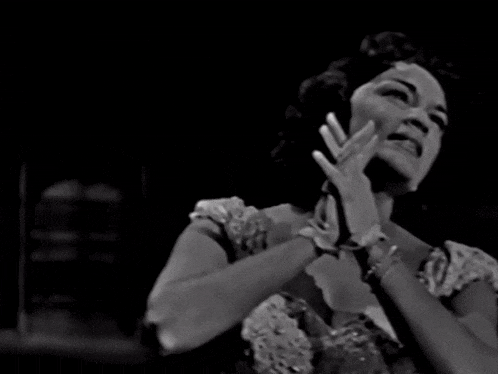 a black and white photo of a woman applauding