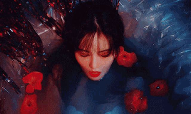 a woman with red lipstick is laying in a pool of water