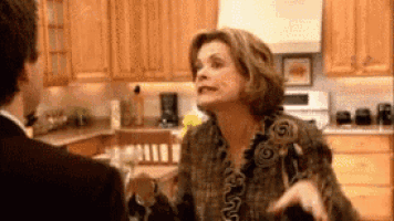 a woman is yelling at a man in a kitchen