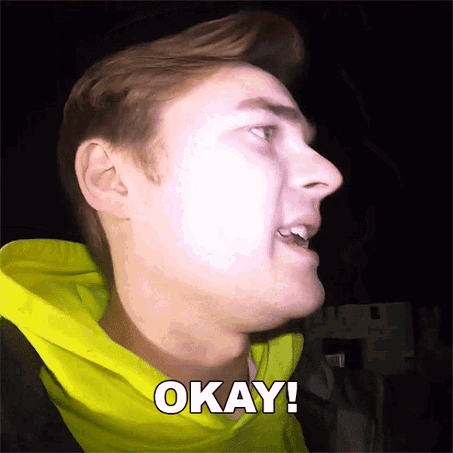 a man wearing a yellow hoodie says okay