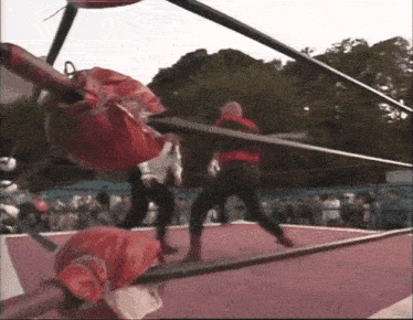 two wrestlers are fighting in a wrestling ring with a crowd watching