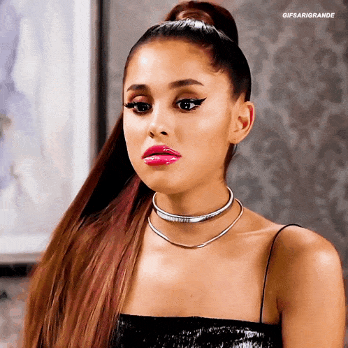 ariana grande is wearing a choker and a ponytail while making a funny face