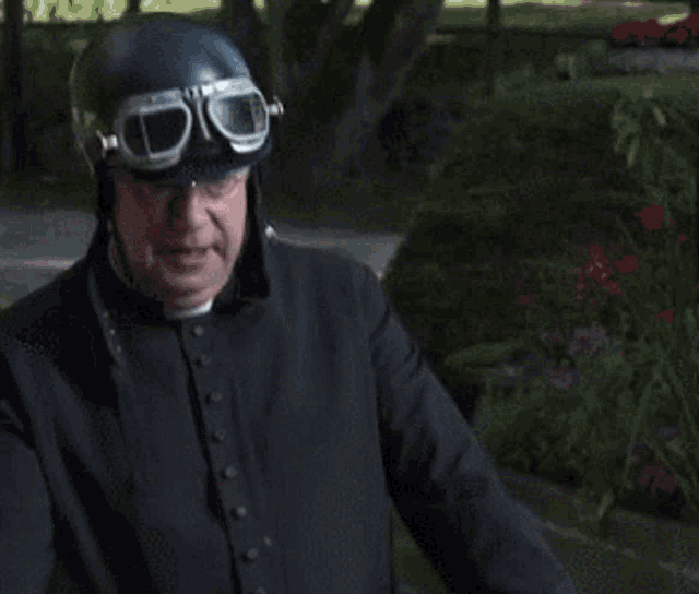 a man wearing a helmet and goggles is standing outside