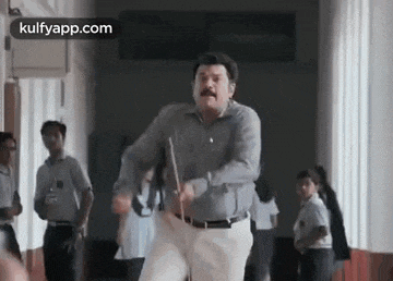 a man is dancing in a hallway while holding a baton .