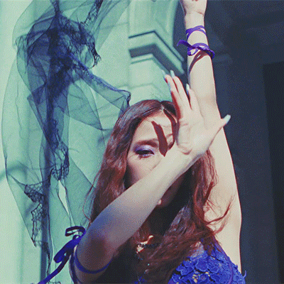 a woman in a blue lace dress is covering her face with her hands