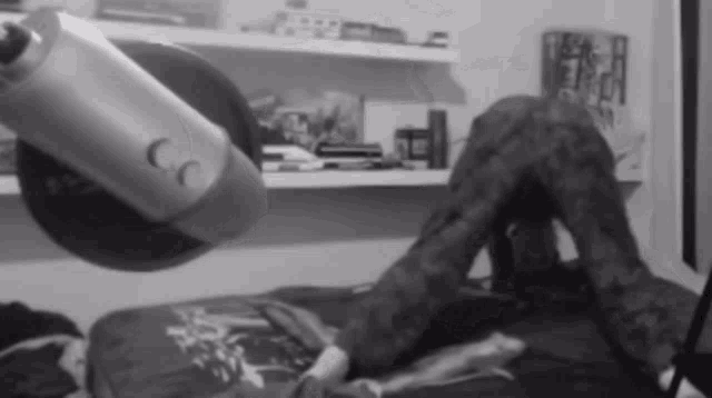 a black and white photo of a person laying on a bed in front of a microphone that says cc