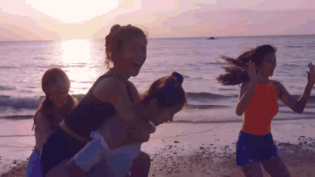 a group of women are playing on a beach at sunset .