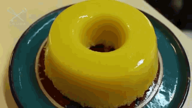 a yellow donut shaped dessert is on a blue plate .