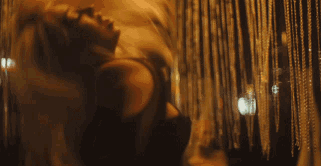 a woman is dancing in front of a curtain with beads