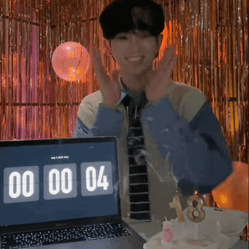 a man stands in front of a laptop that says 00 00 04 on the screen