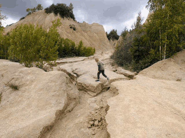 a person is walking across a rocky area