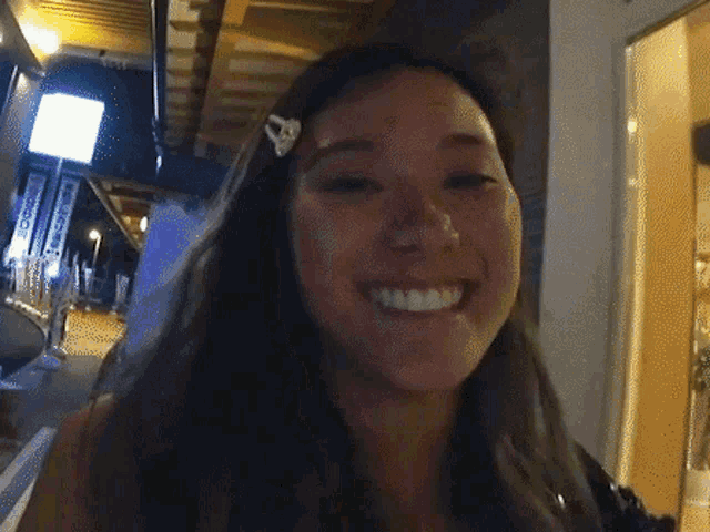 a woman with a clip in her hair smiles at the camera