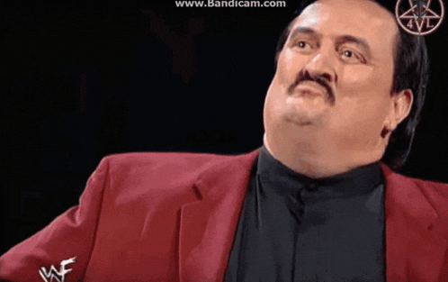 a man with a mustache wearing a red jacket that says wwf on the sleeve