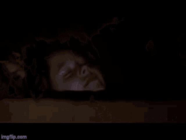 a blurry picture of a man laying on a bed