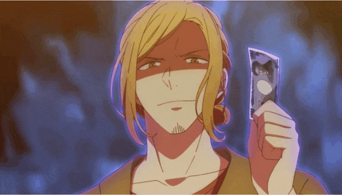 a man with blonde hair is holding a piece of paper with a picture of a cat on it