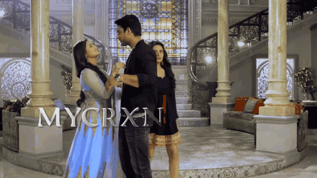 a man and two women are standing in front of a sign that says mycrx1n