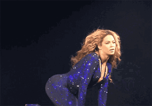 a woman in a blue jumpsuit is kneeling down