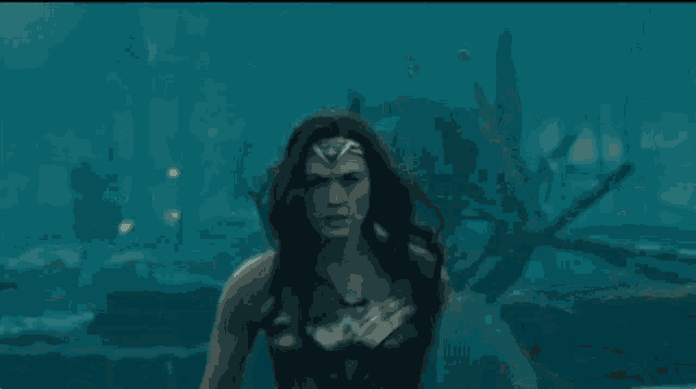 a woman in a wonder woman costume is running through a forest while holding a shield .