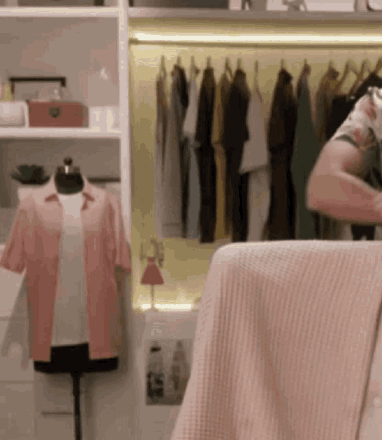 a woman is standing in front of a closet filled with clothes .