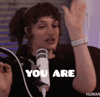 a woman is standing in front of a microphone and says you are .