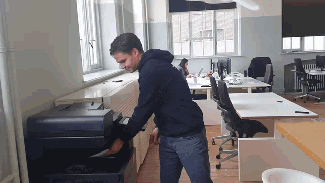a man is using a printer in an office setting