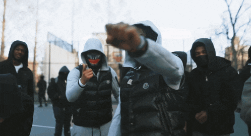 a man wearing a black vest with the word moncler on the front