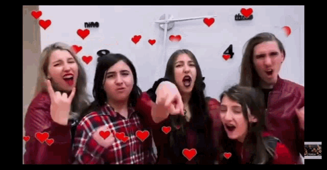 a group of people are standing in front of a white board with hearts and the number 4 on it