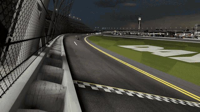 a race track with a checkered finish line and the letter b on the grass