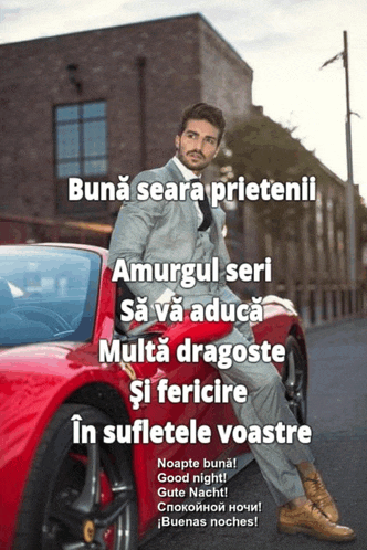 a man in a suit is sitting on the hood of a red car