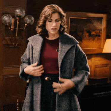 a woman in a grey coat and a red top