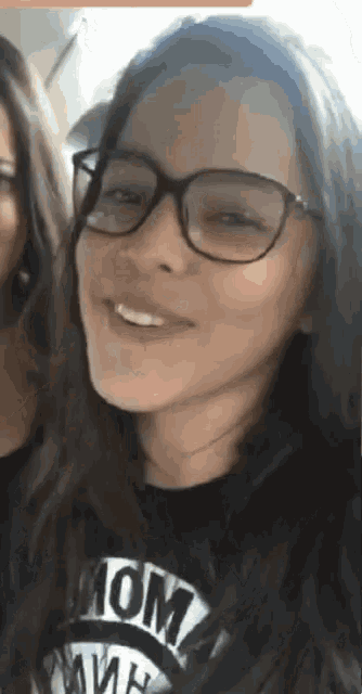 a girl wearing glasses and a shirt that says mom on it