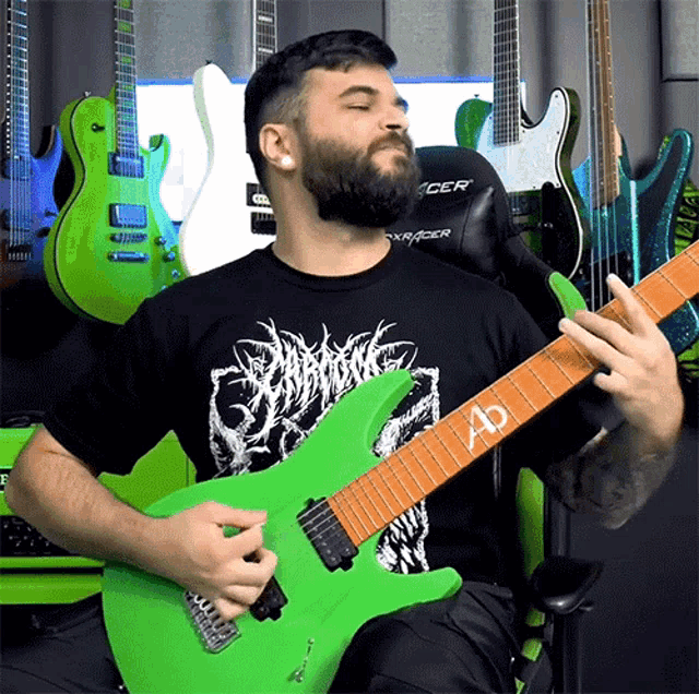 a man with a beard is playing a green guitar with the letter ad on the neck