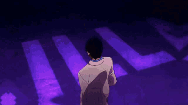 a man in a suit is standing in front of purple lights